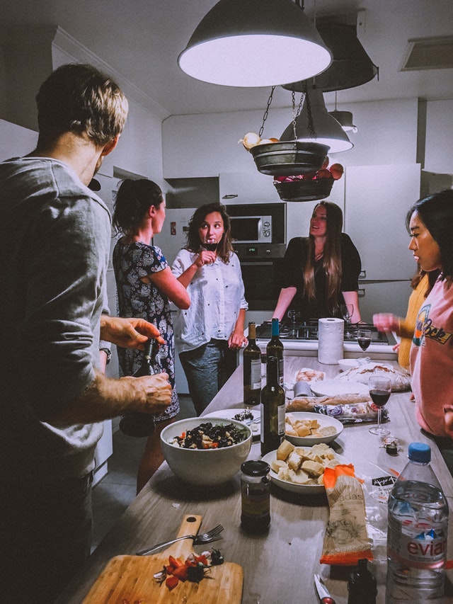 six friends gathered together in a kitchen
